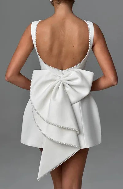 Weisses mini-kleid mit perlenverzierung und schleifenrücken für damen